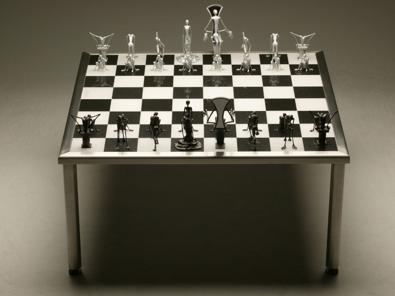 Gesamtaufnahme von Edelstahl-Schachtisch mit künstlerischen Metallfiguren