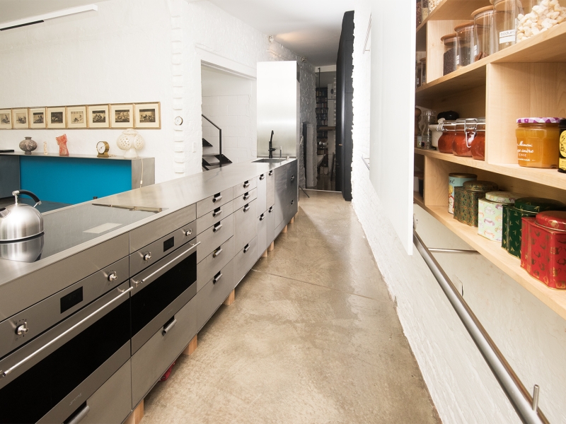 Design-Kochblock in Edelstahl mit Sonder-Vorratsschrank an der Wand hängend